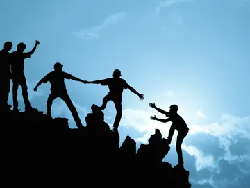 A group of people climbing up the side of a mountain.